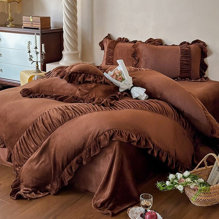Brown ruffled bedding set on a bed in a bedroom setting.
