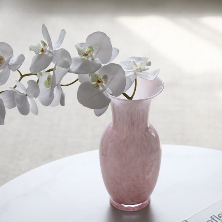 Pink vase with white orchids on a light background