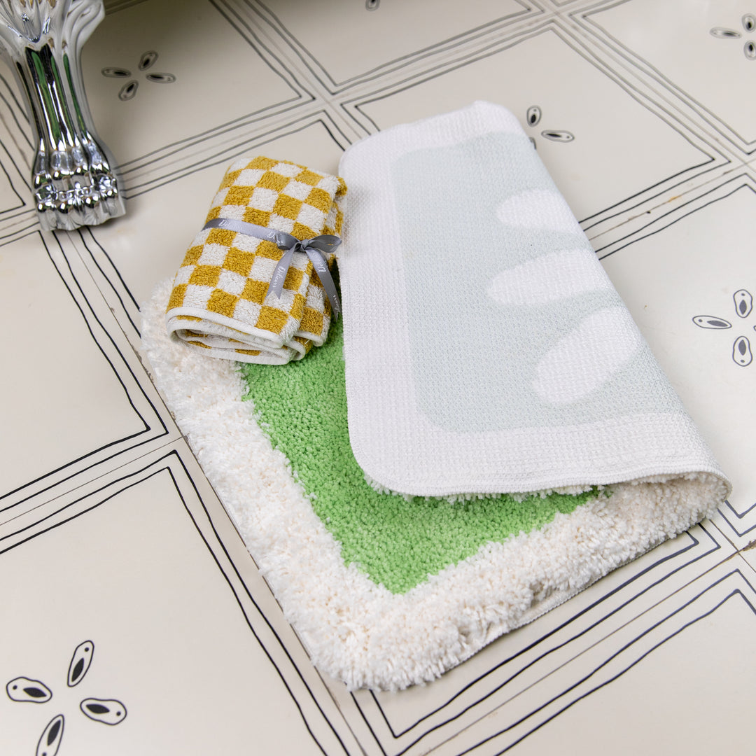 Folded towels with different patterns on a tiled bathroom floor
