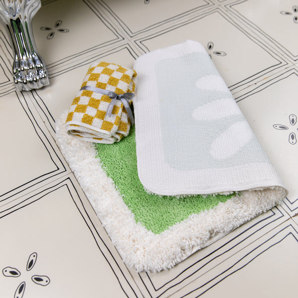 Folded towels with different patterns on a tiled bathroom floor