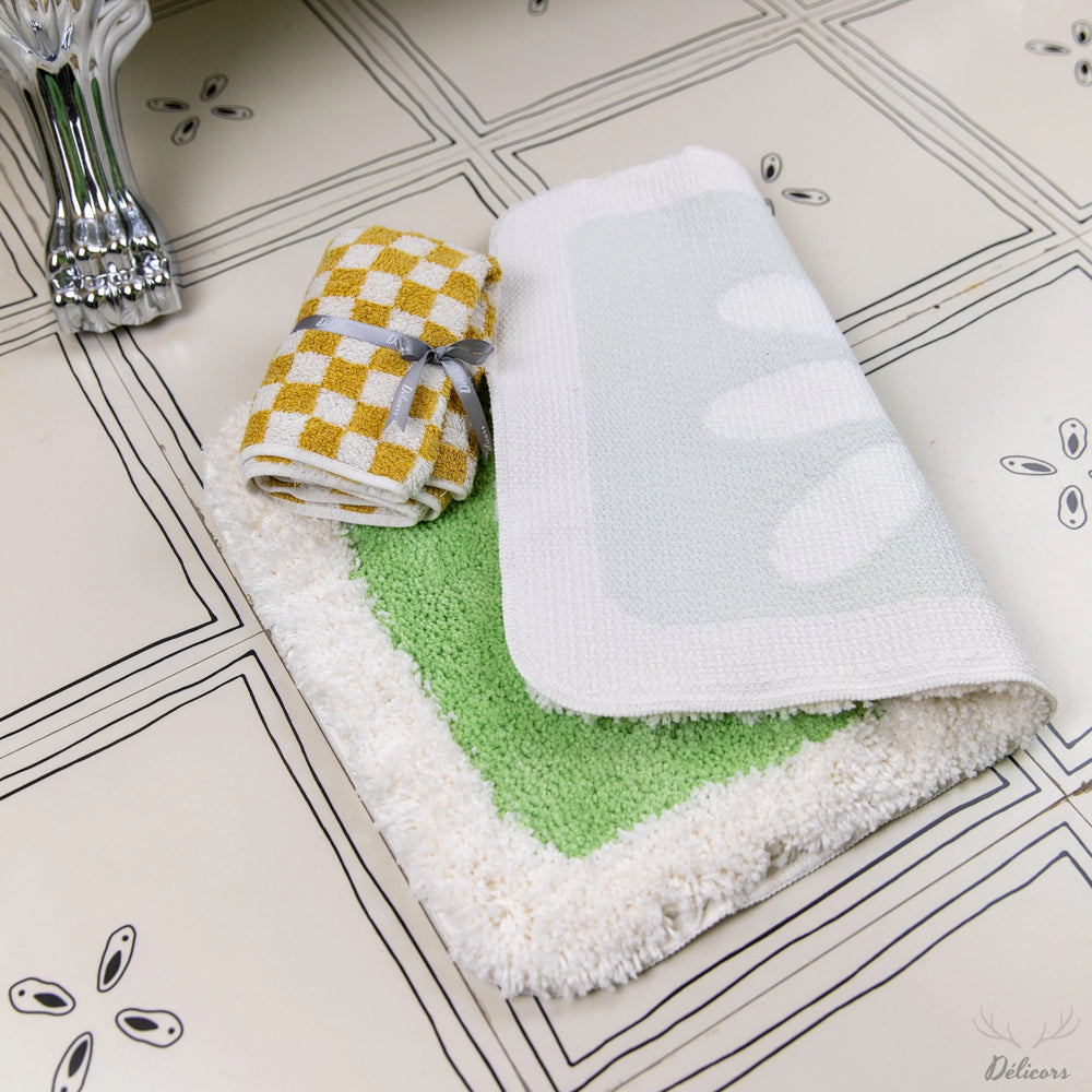 Folded towels with different patterns on a tiled bathroom floor