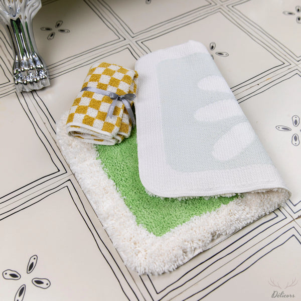 Folded towels with different patterns on a tiled bathroom floor