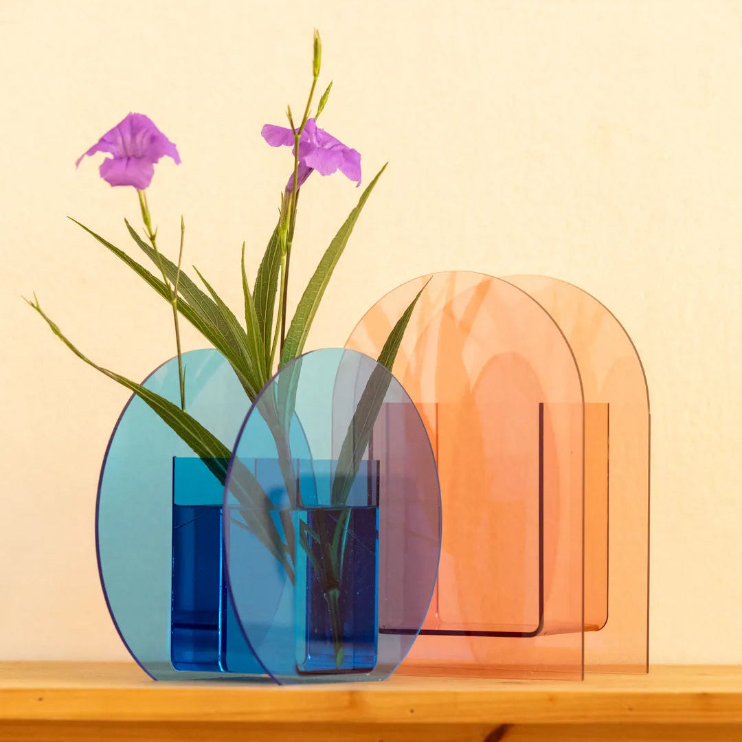 A set of translucent acrylic decorative vases in blue and peach-orange arched and oval shapes